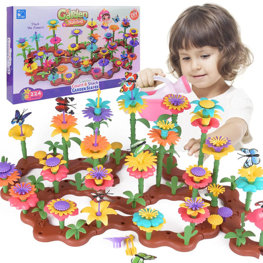 Child playing with a colorful toy garden set, including flowers and a watering can, with the packaging in the background.