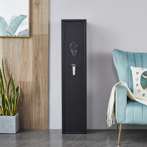 Black gun safe against a gray wall with a teal chair and plant in the foreground