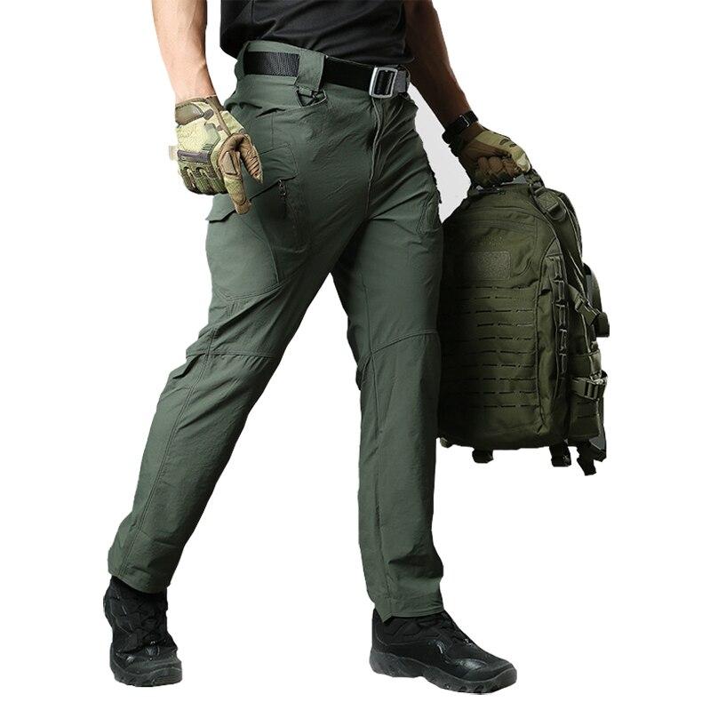 Person wearing green tactical pants with a backpack on a white background