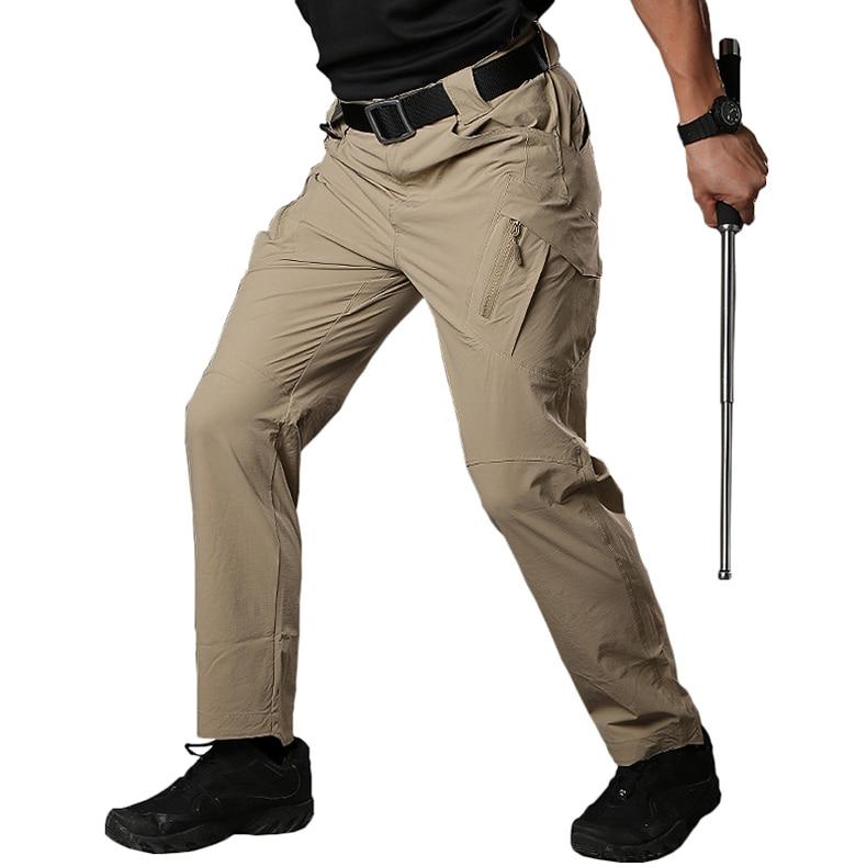 Person wearing beige tactical pants with a white background