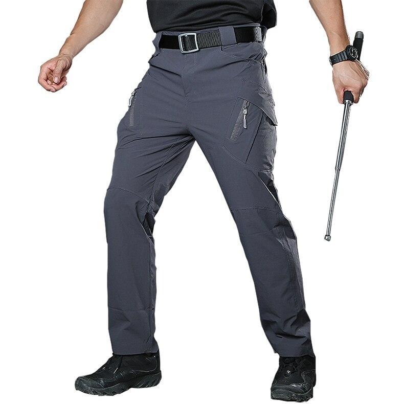 Person wearing gray tactical pants with a white background