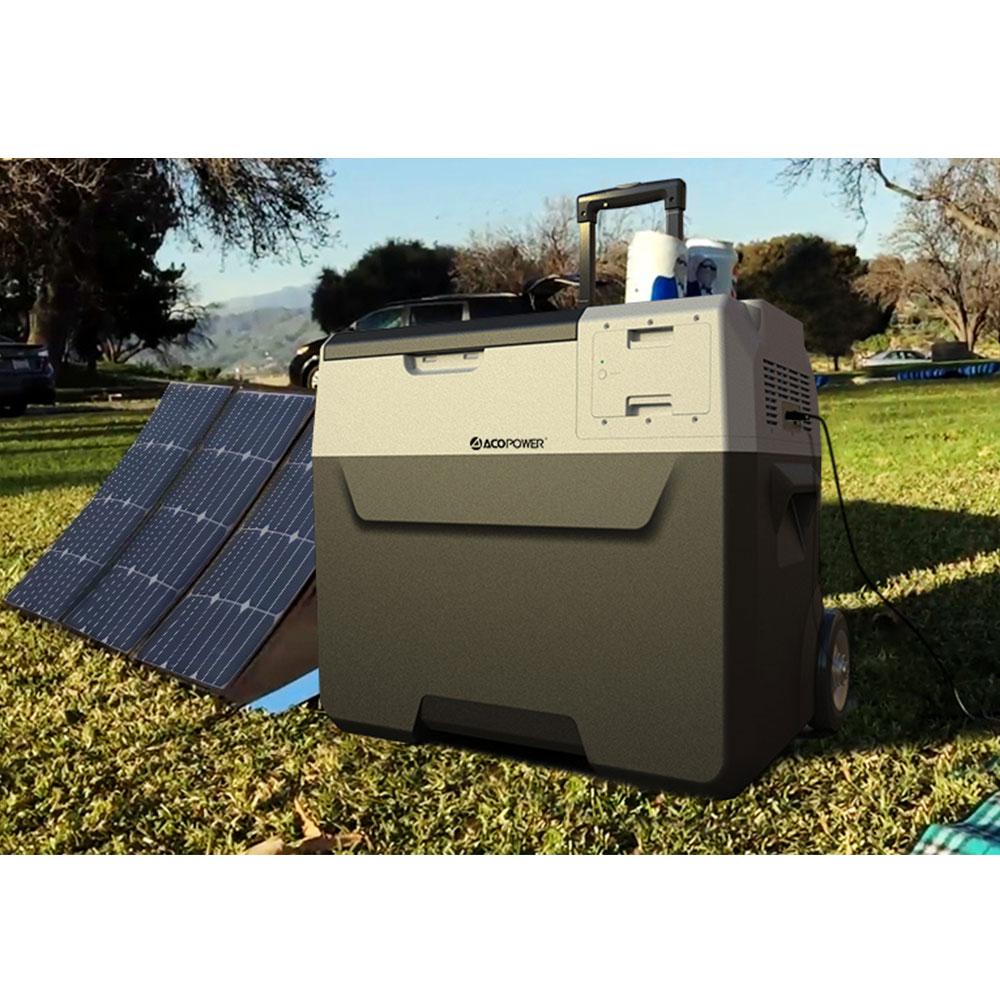 Portable refrigerator with solar panel on grassy area